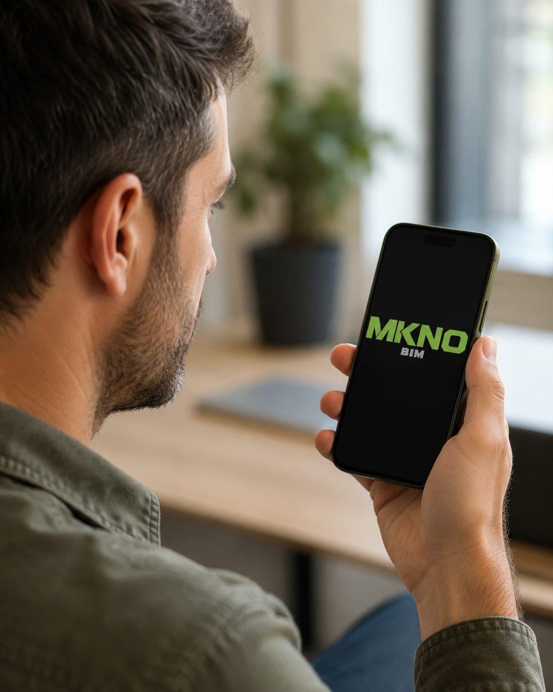 Un hombre sostiene un móvil con MKNO abierto en la pantalla